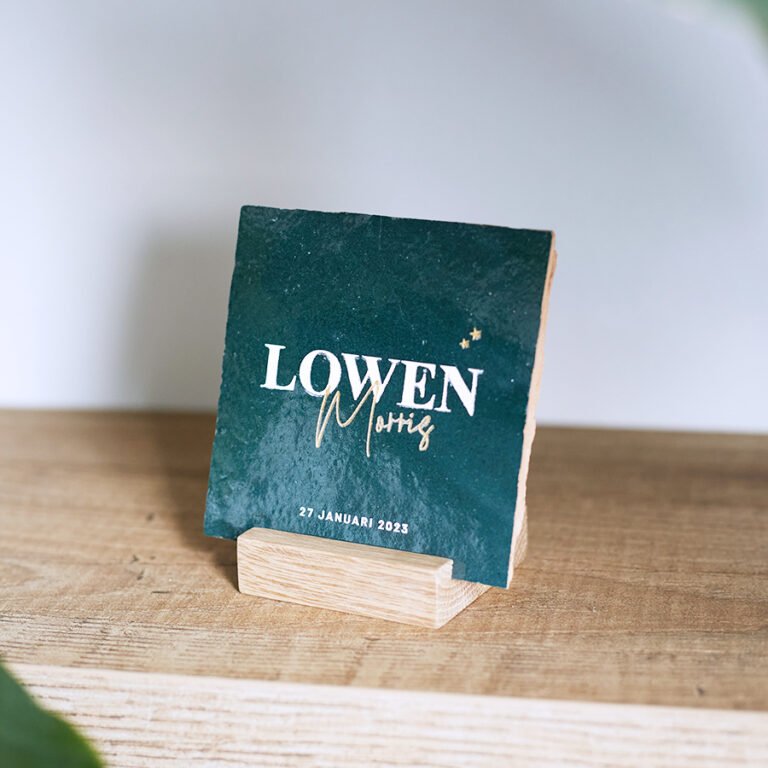 Donkergroen tegeltje op eiken tegelhouder. Gravering naam LOWEN Morris en daaronder geboortedatum.